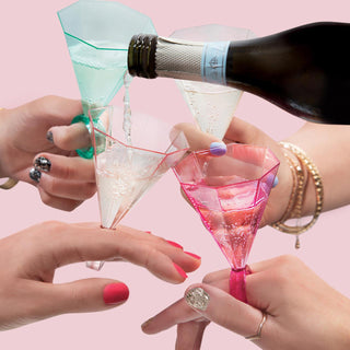 A group of people holding Light Pink Ring Glass Shots in front of a pink background for special occasions by Slant.