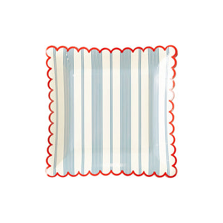 Square, decorative My Mind’s Eye Striped Scallop Plates with vertical blue stripes and scalloped red edges, perfect for a summer coastal style or a patriotic celebration.