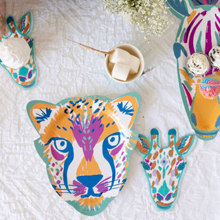 Ma Fête Safari Cheetah Plates, featuring cheetah-shaped designs, are displayed on a white tablecloth alongside a cup of marshmallows and white flowers—ideal for fun safari-themed parties.