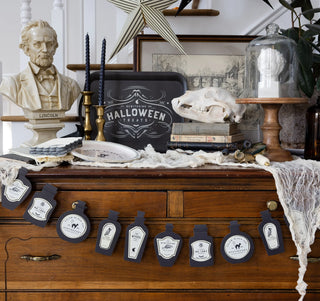 A Salem Apothecary Cat Plate from My Mind’s Eye adorns a dresser for a spooky touch at a Halloween party.