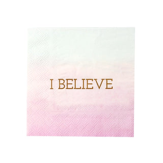 A white and pink gradient napkin with the words "I BELIEVE" printed in gold in the center, perfect for kids party decorations and unicorn party supplies. Introducing the Small Unicorn Napkins from Talking Tables.