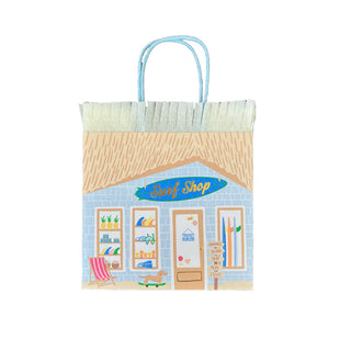 The "Surf's Up Party Bag" from Daydream Society showcases a surf shop illustration, capturing the essence of beachside surf culture with decorations like surfboards and a lounge chair. It features light blue handles and fringe detailing at the top, making it an ideal addition to any celebration with its perfect nod to the "Surf's Up" vibe.