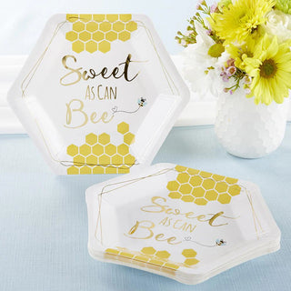 Sweet as Can Bee Cocktail Plates by Kate Aspen with a honeycomb pattern and the text "Sweet as Can Bee" are placed on a blue tablecloth next to a vase of yellow and white flowers, perfect for your baby shower.