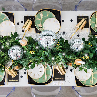A roaring '20s party table setting with gold and green accents, including disco balls and Jollity & Co Gatz Dessert Plates.