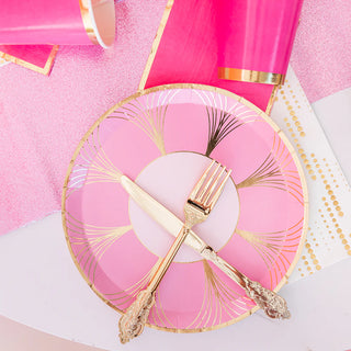 The Gatz Pink Dinner Plates by Jollity & Co showcase an ornate fork and knife design that captures the luxurious essence of the roaring '20s, beautifully complemented by matching pink and gold paper decorations.