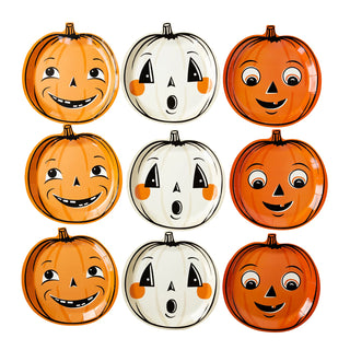 A group of My Mind's Eye Vintage Halloween Trio Pumpkin Shaped Paper Plate Set with faces carved on them.