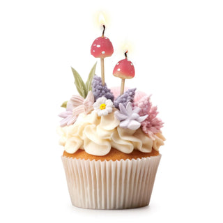 A cupcake decorated with white frosting, pastel-colored flowers, and two Fred and Friends Mushroom Birthday Candles adds an enchanting touch.