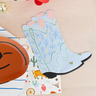 A Yeehaw Large Cowboy Hat Plates and a cowboy boot on a table at a rodeo.