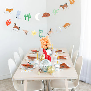 A table with a Yeehaw Large Cowboy Hat Plates setting, featuring paper plates by Daydream Society.