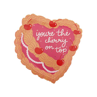 A heart-shaped illustration of a dessert, embellished with vibrant red cherries and the phrase "You're the Cherry On Top," radiates vintage Victorian charm on these Jollity & Co dessert plates, further enhanced by elegant gold foil details.