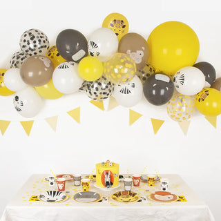 A birthday party table with yellow and black balloons and My Little Day Safari Plates.
