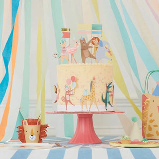 A birthday cake with an Animal Parade Cake Wrap & Toppers of a giraffe on top by Meri Meri.