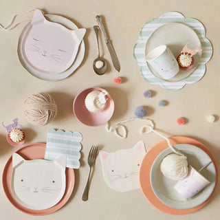 A whimsical table setting featuring cat-themed plates and pastel-colored tableware, adorned with Meri Meri kitten cups, yarn balls, and petite desserts, evoking a cozy, playful atmosphere.