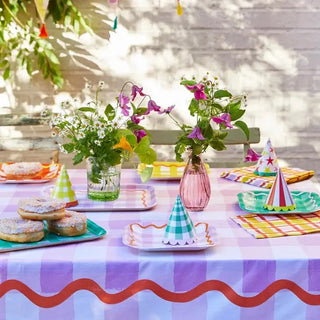 A colorful party table set with Talking Tables Everyone's Welcome Square Paper Plates and cups.