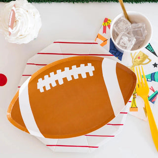 A Good Sport Football Plates themed table setting with a plate, napkin, and fork for team parties. Brand: Daydream Society