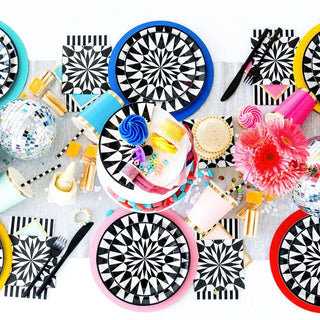 A colorful table setting with Jollity & Co's Kaleidoscope Dinner Plates, cups, and napkins.