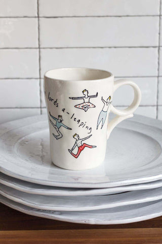 A handcrafted ceramic Ten Lords A-Leaping mug from Accent Decor, featuring a drawing of people and unique imperfections.