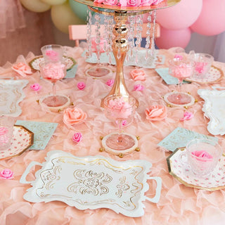 A pink and gold Let Them Eat Cake Platters table setting with roses and cupcakes on it by Daydream Society.