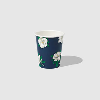 A compostable blue paper cup with white magnolias on it, inspired by Draper James, from Coterie Party Supplies.