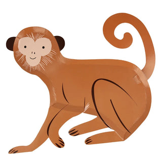 A brown monkey is perched against a white backdrop at the Meri Meri Monkey Plates themed party.