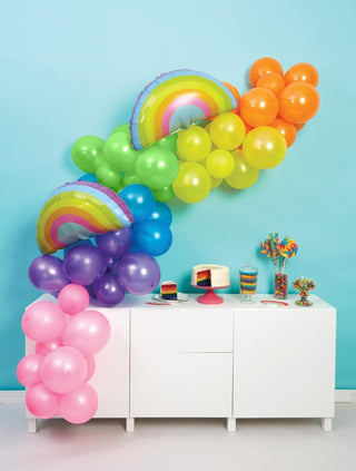 A colorful OVER THE RAINBOW BALLOON GARLAND on a white dresser, creating an enchanting display by CR Gibson.