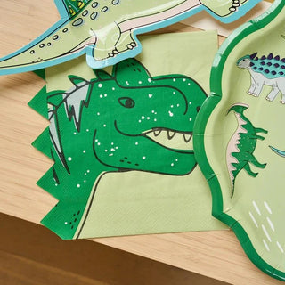A collection of colorful Sophistiplate Dinosaur Dinner Plates, including a prominent green t-rex with ruffled green edge plates, placed atop a wooden surface, suggesting a children's arts and crafts activity.