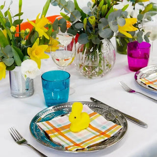 An Easter table setting with Rainbow Mini Easter Bunnies plates, napkins, and a rubber duck from Talking Tables. Decorated with rainbow colors.