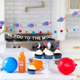 Rocket Mini Banner Set﻿This outer space banner set is the perfect backdrop for your out of this world party. Includes rocket ships, felt colored pom poms and the phrase 'love you to the mMeri Meri