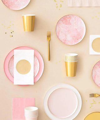 Elegant party table setting featuring a pastel pink and gold color scheme with coordinated Oh Happy Day Rose Quartz Plates - 7 inch, cups, and golden utensils designed in San Francisco, set against a soft beige backdrop, accentuated.