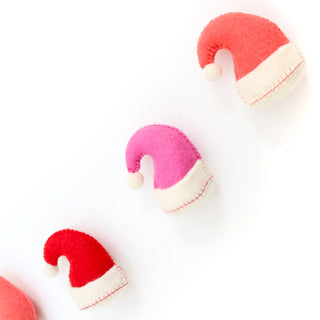 Santa Hat Christmas Holiday Felt GarlandDress up your holiday decor with a Santa Hat Christmas Garland! This festive felt garland is perfect for adding some jolly Santa style to your home. Hang it on your Kailo Chic